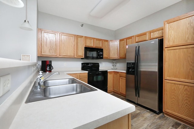 kitchen with light brown cabinetry, sink, black appliances, pendant lighting, and light hardwood / wood-style floors