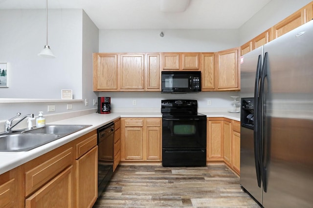 kitchen featuring light brown cabinetry, dark hardwood / wood-style flooring, sink, black appliances, and decorative light fixtures