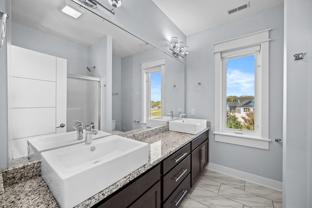 bathroom featuring vanity, toilet, and an enclosed shower