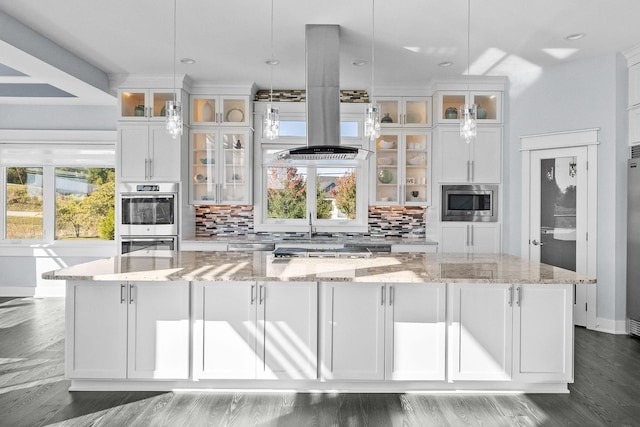 kitchen featuring decorative light fixtures, a spacious island, white cabinetry, and tasteful backsplash