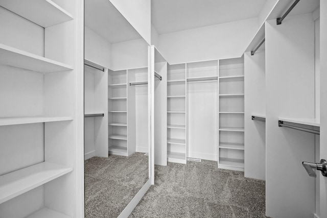 walk in closet featuring dark carpet