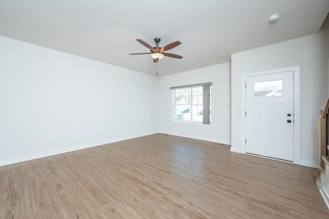 entryway with ceiling fan, light hardwood / wood-style floors, and a textured ceiling