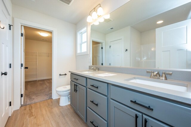 bathroom with vanity, toilet, wood-type flooring, and a chandelier