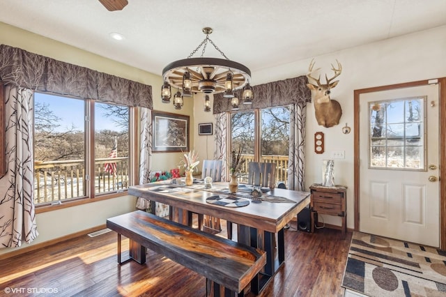 dining space featuring ceiling fan with notable chandelier and dark hardwood / wood-style flooring