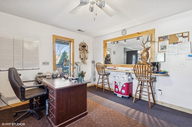 office space featuring ceiling fan, dark tile patterned flooring, and a textured ceiling