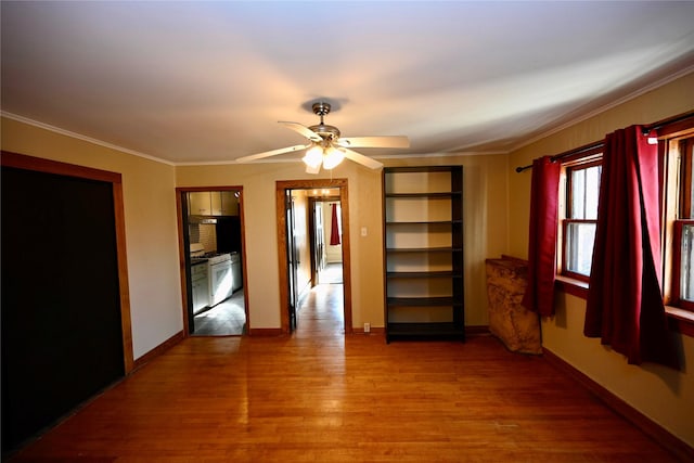 unfurnished room featuring ceiling fan, wood-type flooring, and ornamental molding