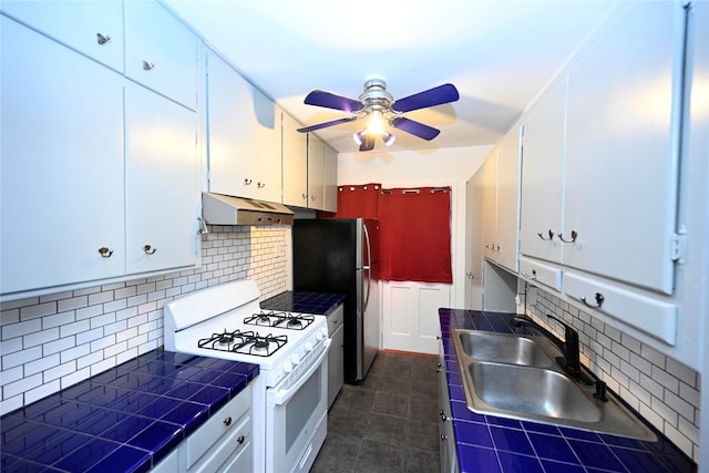 kitchen featuring white cabinetry, gas range gas stove, sink, backsplash, and tile countertops