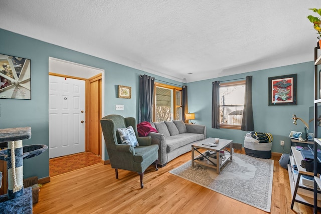 living room with a textured ceiling and light wood-type flooring