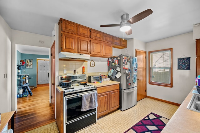 kitchen with sink, stainless steel fridge, decorative backsplash, white range, and ceiling fan