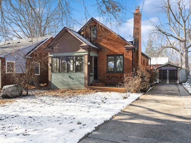 bungalow-style house featuring a garage and an outbuilding