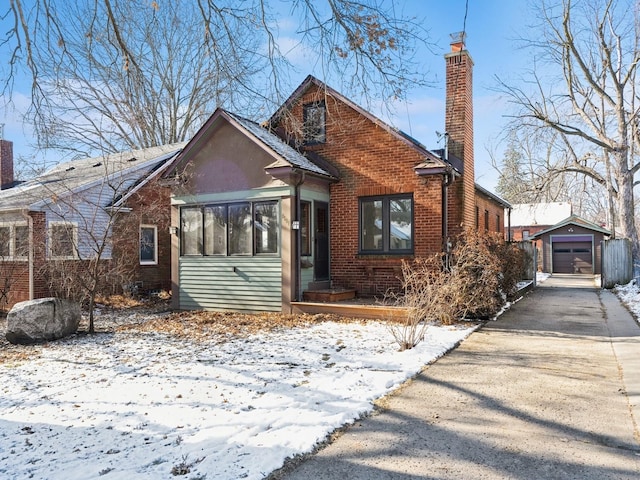 bungalow-style home featuring a garage and an outbuilding