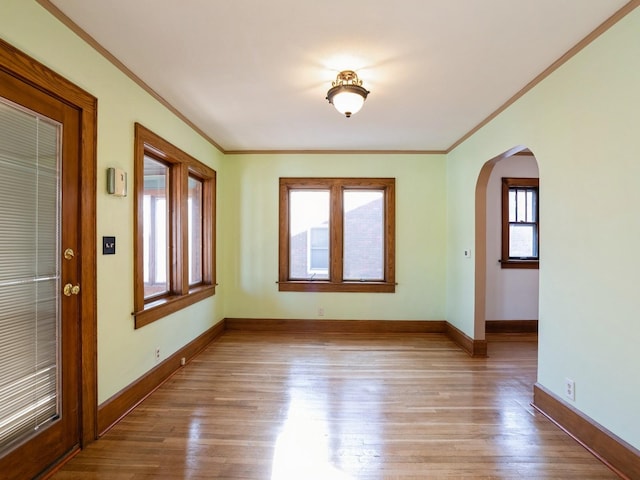 spare room featuring light wood-type flooring and crown molding