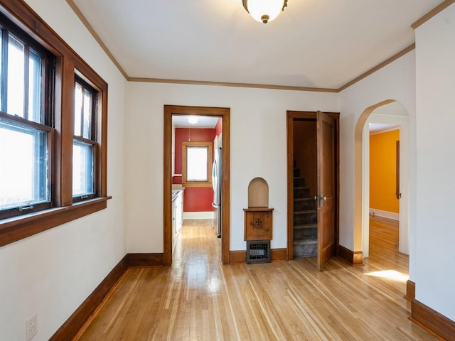 interior space featuring light hardwood / wood-style floors, a wealth of natural light, and ornamental molding