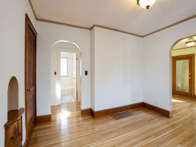 unfurnished room featuring light wood-type flooring and crown molding