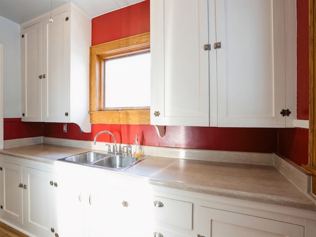 kitchen featuring white cabinetry and sink