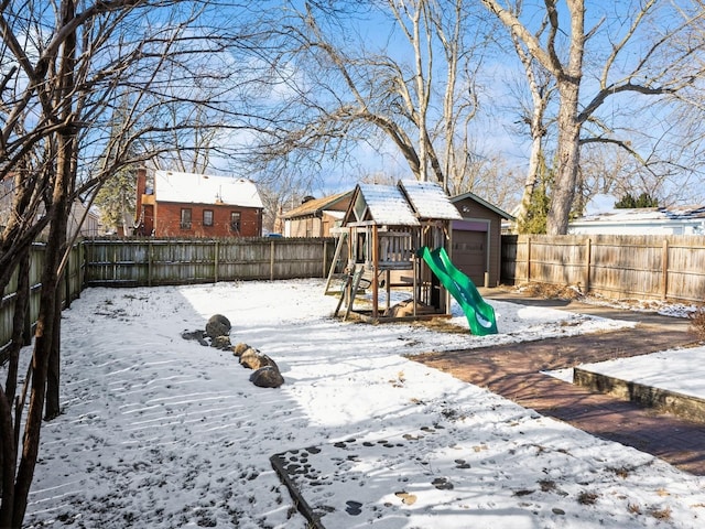 snowy yard featuring a playground