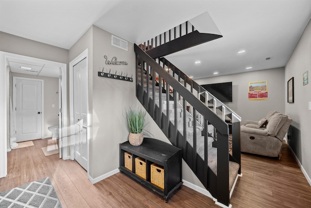 staircase with recessed lighting, visible vents, baseboards, and wood finished floors