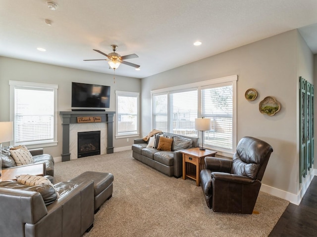 living room featuring a fireplace, hardwood / wood-style flooring, and ceiling fan