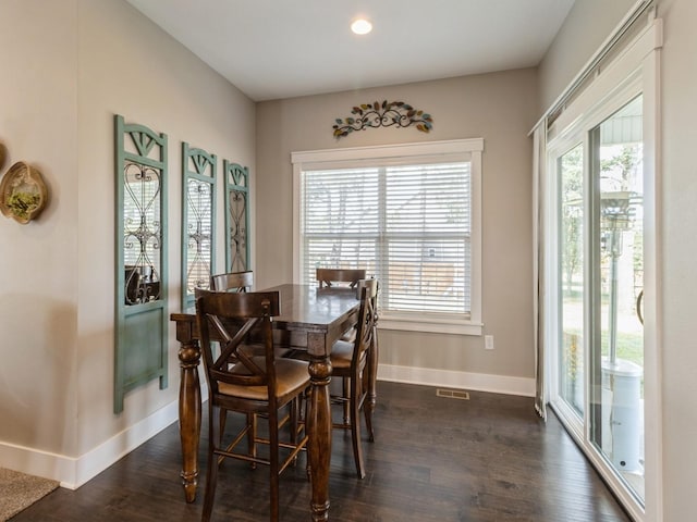 dining space with a healthy amount of sunlight and dark hardwood / wood-style floors