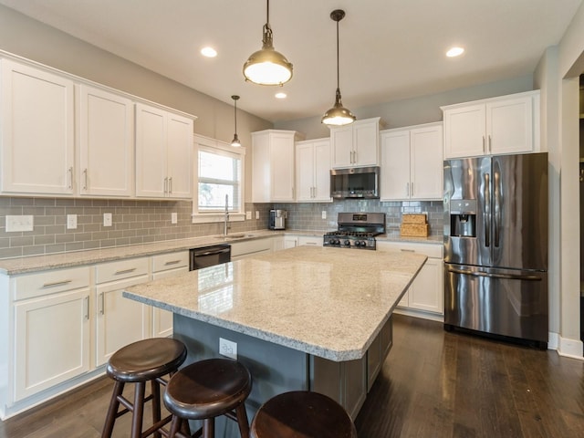 kitchen with white cabinets, appliances with stainless steel finishes, and a center island