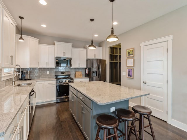 kitchen featuring a center island, sink, white cabinets, and appliances with stainless steel finishes