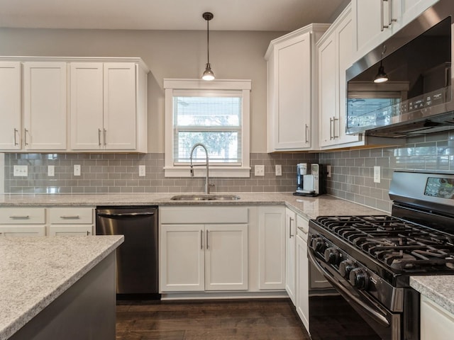 kitchen with sink, decorative backsplash, light stone countertops, appliances with stainless steel finishes, and white cabinetry