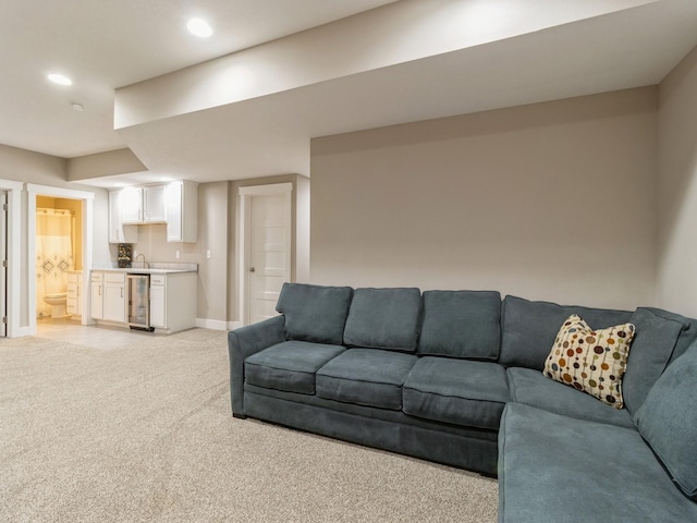 carpeted living room with wine cooler and sink