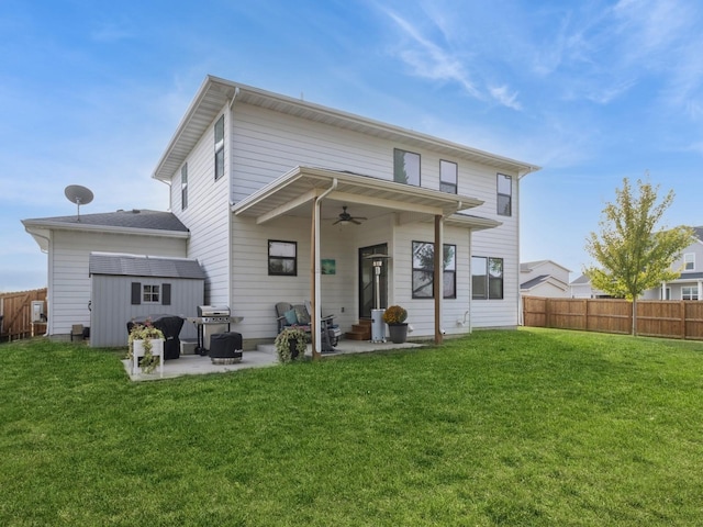 back of house with a patio area, a yard, and a storage shed