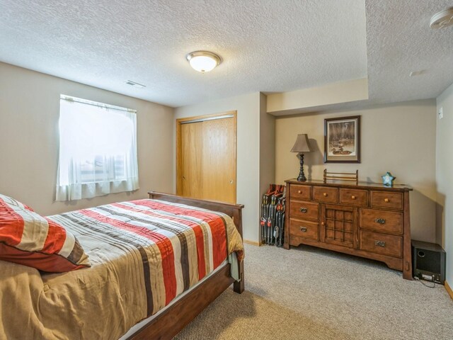 carpeted bedroom with a closet and a textured ceiling