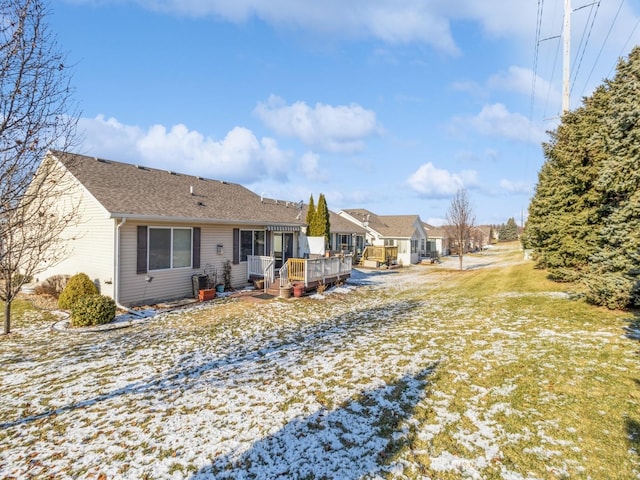 snow covered rear of property with a wooden deck