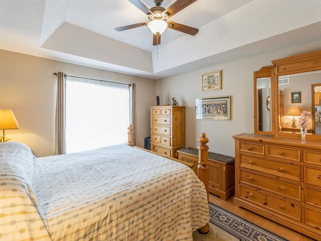 bedroom with a tray ceiling and ceiling fan