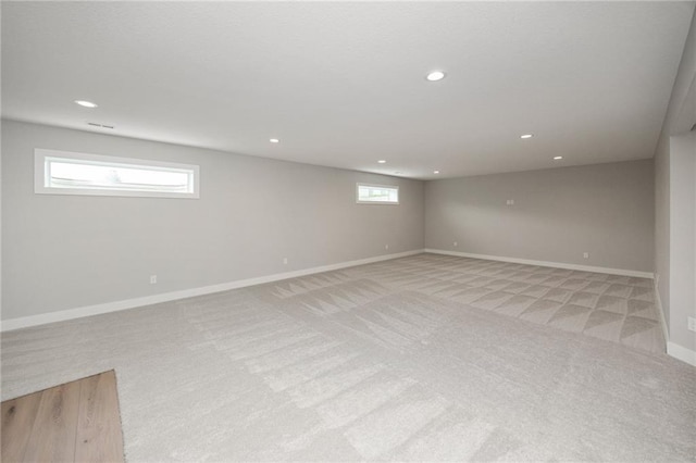 basement featuring a healthy amount of sunlight and light colored carpet