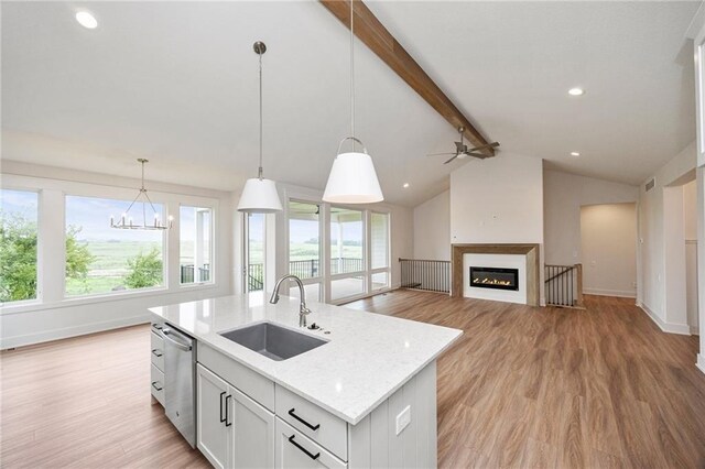 kitchen with white cabinets, sink, decorative light fixtures, dishwasher, and an island with sink