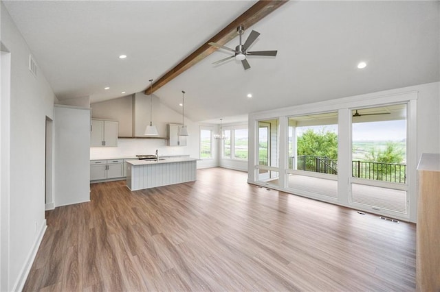 unfurnished living room featuring sink, a wealth of natural light, and light hardwood / wood-style flooring