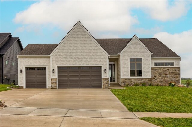 view of front of home with a garage, a front yard, driveway, and stone siding
