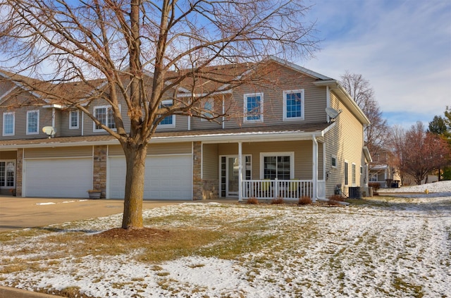 view of front facade with covered porch, central AC unit, and a garage