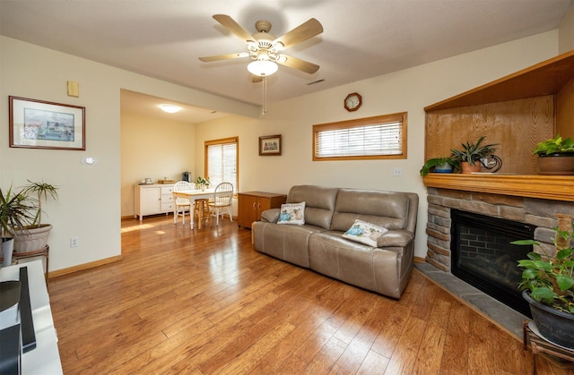 living room with ceiling fan, a healthy amount of sunlight, and light hardwood / wood-style flooring