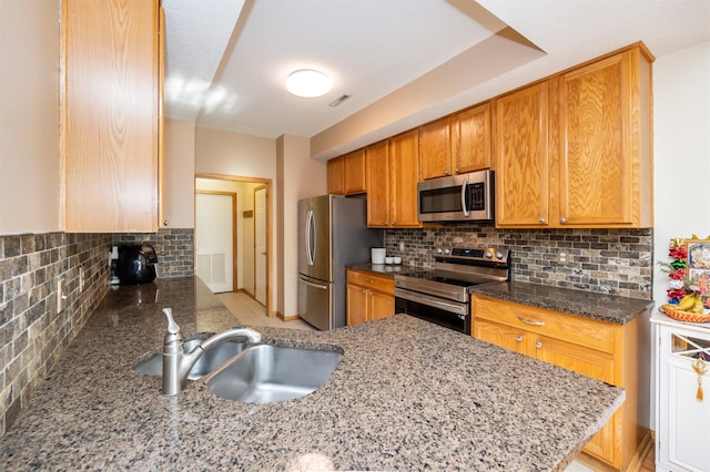 kitchen with stone countertops, tasteful backsplash, sink, kitchen peninsula, and stainless steel appliances