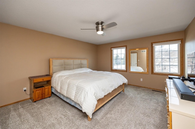 carpeted bedroom with multiple windows and ceiling fan