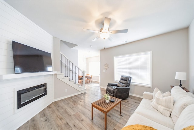 living room with ceiling fan and light hardwood / wood-style floors