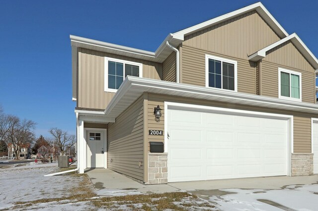 view of front of property with a garage and central AC