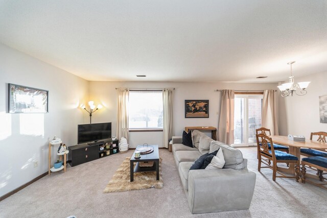 living room with light carpet and a notable chandelier