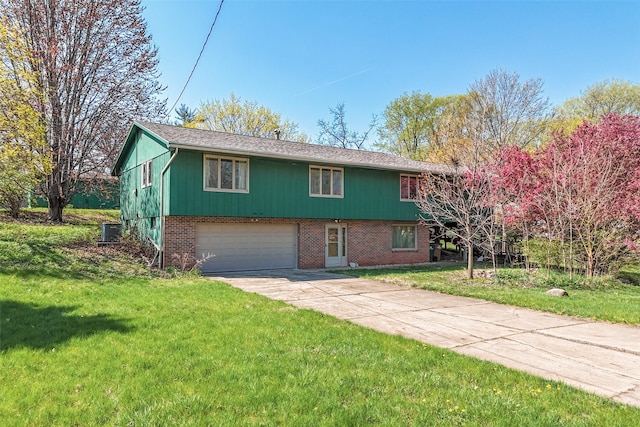 raised ranch with concrete driveway, a front lawn, brick siding, and a garage