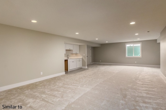 basement with light colored carpet and sink