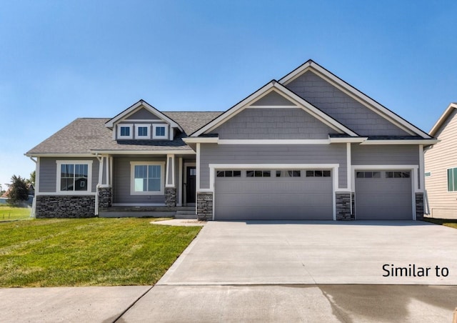 craftsman house featuring a garage and a front yard