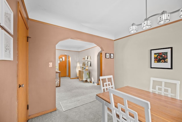 carpeted dining room featuring crown molding