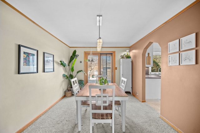 carpeted dining space featuring ornamental molding and sink