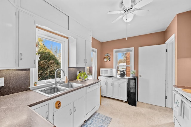 kitchen with white appliances, sink, ceiling fan, white cabinetry, and beverage cooler