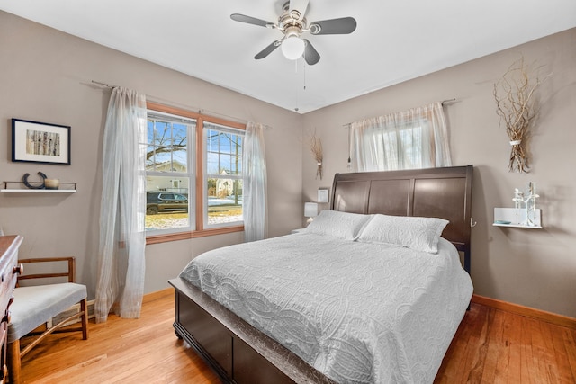 bedroom with multiple windows, ceiling fan, and light wood-type flooring