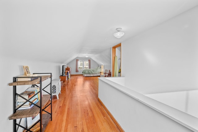 hallway featuring light hardwood / wood-style floors and lofted ceiling